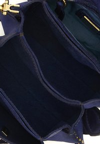 Borsa a tracolla in pelle scamosciata blu navy con tre scomparti, ferramenta dorata e fodera interna testurizzata. Presenta cuciture e una finitura morbida.