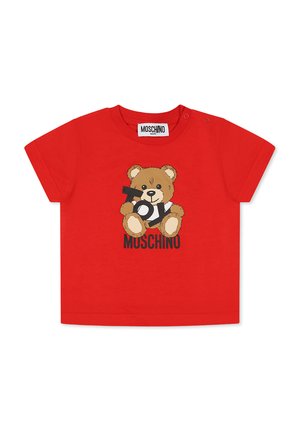 Maglietta per bambini a maniche corte rossa in cotone con una grafica di un orso che tiene la parola "TOY" e "MOSCHINO" sotto in nero. Due chiusure a scatto sulla spalla.