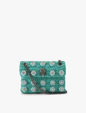 Turquoise geweven handtas met zilveren bloemrijke versieringen, een decoratieve sluiting in de vorm van een hand, en een dikke zilveren kettingriem.