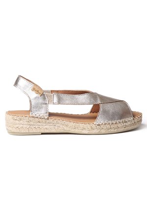 Sandalia espadrille de cuero plateado metálico con diseño de punta abierta, suela tejida de yute y correa ajustable para un ajuste seguro.