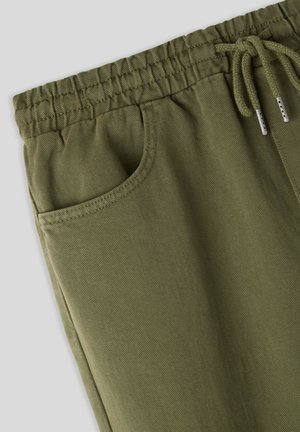 Pantaloni jogger verde oliva realizzati in tessuto morbido, dotati di una vita elastica con cordoncino, tasche laterali e superficie testurizzata.