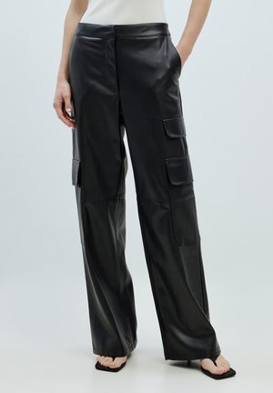 Zwarte leren cargobroek met een relaxte pasvorm, wijde benen, vo pockets en een gladde textuur. Accenten zijn onder andere details van flapzakken.