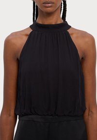 Black halter top in lightweight fabric, featuring a gathered neckline, smooth texture, and a loose fit ending just above the waist.