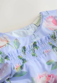 Hellblaues Blumenkleid mit gerafftem Ausschnitt. Mit rosa Rosenmustern und grüner Vegetation, aus weichem, leichtem Stoff gefertigt. Etikett sichtbar.
