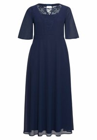Mörkblå klänning med korta, flödande ärmar, ett triangulärt spetsdetalj vid halsringningen och en figurnära midja med en utsvängd kjol.