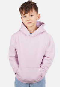Ljusrosa hoodie i mjukt tyg med en framficka och ribbade ärmar. Har en rymlig huva och en etikett nära fållen.