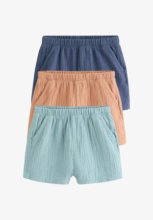 Trois paires de shorts en coton texturé empilées, en bleu, beige et bleu clair, chacune avec une taille élastique et des poches latérales.
