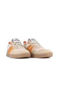 Sneaker in suede beige con strisce in tessuto arancione, lacci bianchi e suola in gomma. Presenta un'inserzione marrone sul tallone e un'etichetta con logo.