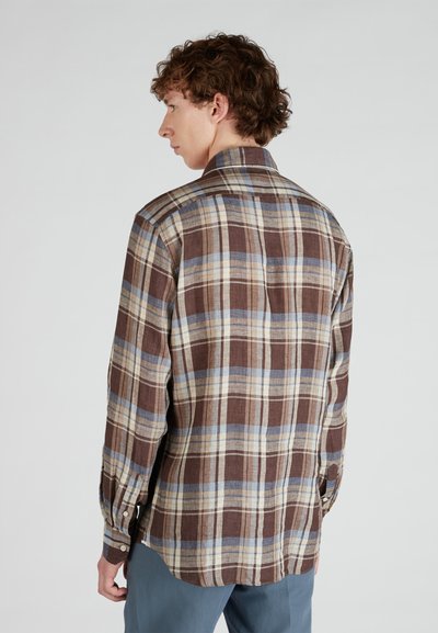 Camicia a quadri marrone con accenti blu e crema. Maniche lunghe, polsini con bottoni e dettaglio sul retro. Realizzata in un tessuto testurizzato.