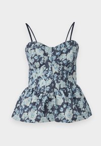 Blommig peplumtop med justerbara band, med en mörk marinblå bakgrund och ljusblå blommor, tillverkad av texturerat tyg.