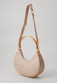 Beige handväska i halvmåneform, med ett texturerat tyg med logomönster, läderdetaljer och en justerbar axelrem.