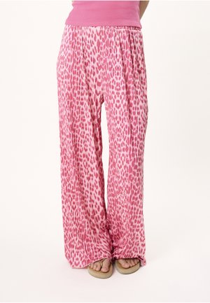 Løse pink leopardprint bukser båret med beige sandaler og en pink ribbet ærmeløs top, vist fra taljen til fødderne mod en hvid baggrund.