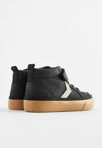 Svart högkrumpsneakers med en texturerad läderöverdel, med en ljus färgaccent och en sula av gummirubber. Lämpliga för avslappnad användning.