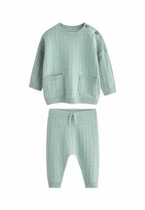 Mintgrön set i stickat material med ett strukturerat mönster. Toppen har två fickor och dekorativa knappar, medan byxorna har ett midjeband med dragsko.