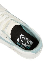 Fehér és világoskék Vans sneaker belseje, amelyen lágy fekete talpbetét látható "Vans ComfyCush" logóval, textúrált szövettel és fűzési részletekkel.