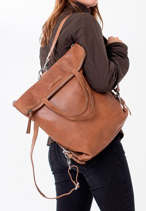 Brown leather tote bag with zippered top, dual handles, and a detachable shoulder strap. Smooth texture and minimalist design.