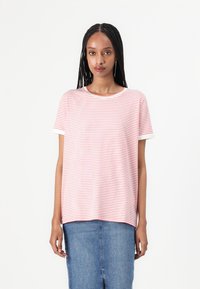 Striped t-shirt in light pink and white, featuring short sleeves, a round neckline, and a relaxed fit. Paired with a denim skirt.