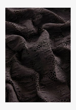 Black fabric with intricate lace patterns, featuring a textured surface and soft draping, highlighting detailed stitching and cutouts.