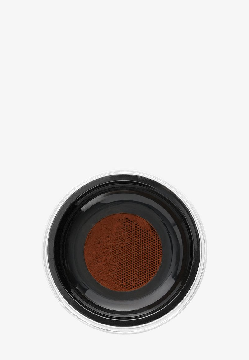 Svart keramisk bolle med en blank kant, som inneholder fint malt brunt kaffe, med en teksturert, perforert overflate.