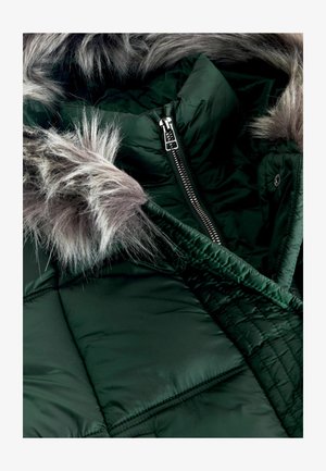 Geacă puffer de culoare verde închis, cu fermoar frontal, având un detaliu de glugă din blană sintetică gri detașabil și o textură matlasată.