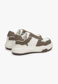 Grube sneakersy w brązowo-białej kolorystyce, wykonane ze skóry i tkaniny, o zaokrąglonym kształcie, z grubą podeszwą i teksturowanymi akcentami.