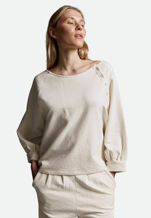 Hellbeige, Baumwoll-Sweatshirt mit weitem Ausschnitt, langen Puffärmeln und Knopfdetail an der Schulter. Weiche Textur, lässige Passform.