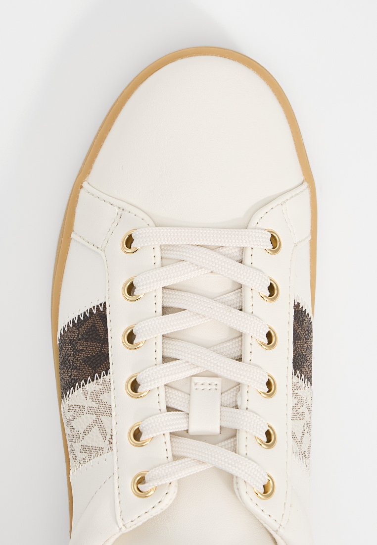 Zapatilla de piel blanca con un patrón decorativo marrón, con ojales dorados y cordones blancos. Suela de goma en color natural.