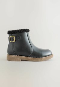 Schwarze Leder-Ankle-Boots mit einem strukturierten schwarzen Fellbund, goldfarbener Schnalle und einer hellbraunen, strukturierten Sohle. Runder Zehenbereich.