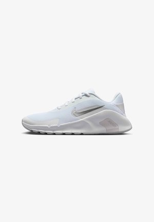 Zapatilla de running Nike blanca de perfil bajo con parte superior de tela texturizada, suela blanca y logo Swoosh plateado en el lateral.