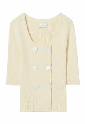 Top de color crema con textura acanalada, mangas cortas, escote redondo y seis botones blancos decorativos en la parte delantera. Textura suave y diseño ligero.
