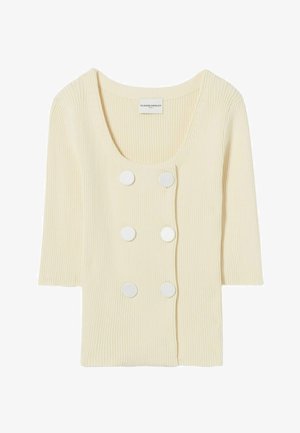 Top de color crema con textura acanalada, mangas cortas, escote redondo y seis botones blancos decorativos en la parte delantera. Textura suave y diseño ligero.