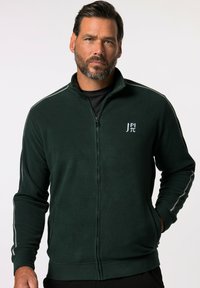 Giacca zip-up in pile verde scuro con colletto alto, strisce grigie di accento sulle maniche e un piccolo logo ricamato sul petto.
