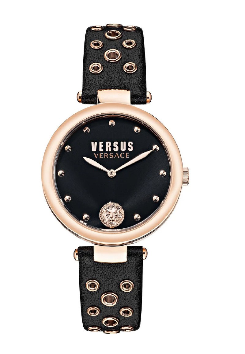 Versus Versace laikrodis turi juodą ciferblatą, rožinio aukso akcentus, odinį dirželį su metaliniais skylutėmis ir liūto emblema 6 valandos pozicijoje.
