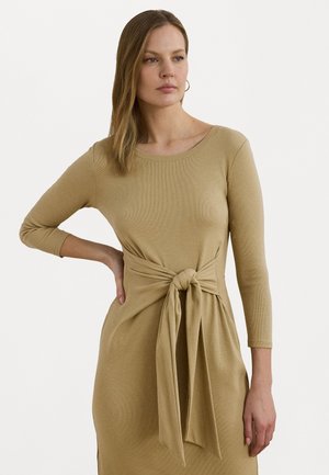 Knit dress in sandy beige with a round neckline, long sleeves, and a front tie accent at the waist. Features ribbed texture.