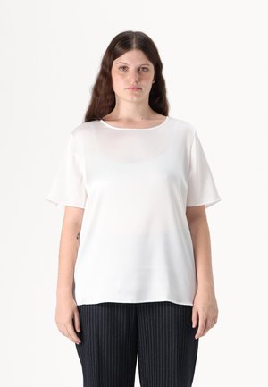 Witte blouse met korte mouwen en een gladde textuur, met een ronde halslijn, gecombineerd met marineblauwe broek met streepjes voor een contrast in kleur en patroon.
