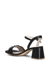 Černé sandály na podpatku s pleteným designem pásků, otevřenou špičkou a páskem kolem kotníku. Blokový podpatek zajišťuje stabilitu. Hladké a strukturované materiály.