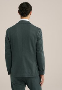 Dark green textured suit jacket with a single vent, notch lapels, and buttoned cuffs. Tailored fit, viewed from the back.