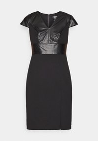 Robe noire mi-longue aux genoux avec manches courtes, corsage à encolure en V en similicuir et large ceinture en similicuir.