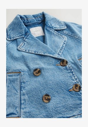 Šviesiai mėlynas dvigubos eigos džinsinis švarkas su rudais mygtukais, ryškiais siūlės ir įpjautu apykakle. Viduje matomas etiketas.