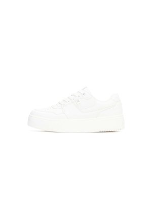 Zapatilla blanca con parte superior de cuero suave, puntera redondeada, cordones planos, cuello acolchado y suela gruesa de goma con dibujo texturizado.