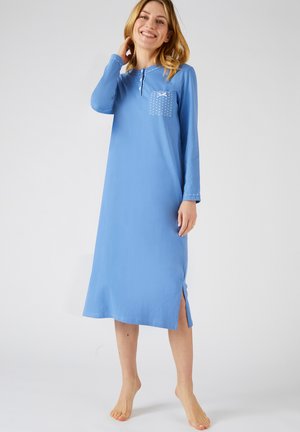 Maglietta da notte lunga blu con maniche lunghe e tasca, decorata con pois bianchi e un design a fiocco, con fondo spaccato su un lato e texture del tessuto morbida.
