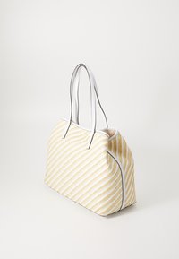 Sac fourre-tout à rayures jaunes et blanches avec un design tissé texturé, doté de poignées en cuir blanc et de détails en simili cuir noir contrastants.
