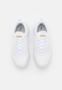 Chaussures de sport blanches avec un design rembourré, dotées d'une tige en cuir texturé, d'un laçage à l'avant, d'une languette à l'arri ère et d'accents de logo dorés.