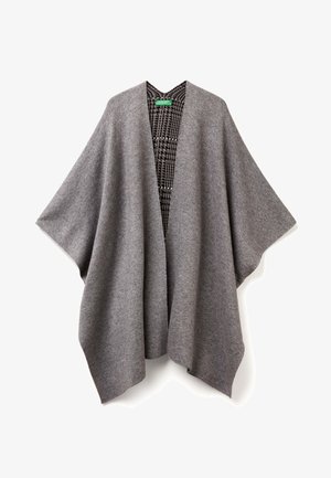 Šedý vlněný pončo s širokými rukávy a otevřeným předním dílem. Na vnitřní straně je viditelný černobílý vzor houndstooth. Měkká textura.