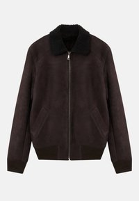 Tummanruskea mokkanahkainen bomber-takki, jossa on musta lampaanvilla-kaulus, etuvetoketju, viistot sivutaskut sekä ribbireunat hihansuissa ja helmassa.