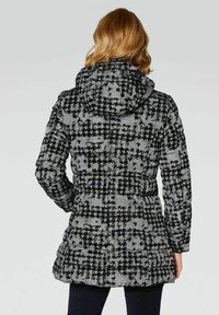 Pikowana czarno-biała kurtka puchowa z kapturem; posiada wzór w kratę, elastyczne mankiety i długość sięgającą do połowy uda.