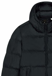 Veste matelassée noire avec col haut, fermeture éclair et texture matelassée. Comprend des poches latérales et une finition douce et brillante.