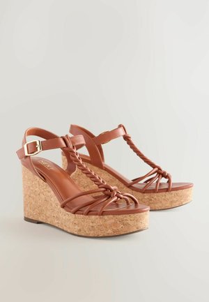 Sandale cu toc wedge împletite, de culoare marron, cu platformă din plută și talpă plată. Caracteristici: cataramă reglabilă și un design texturat, țesut.