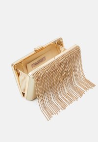 Złota wieczorowa torebka kopertowa z metaliczną ramą, satynowym wnętrzem i opadającymi ozdobami z kryształowych frędzli. Wewnątrz widoczna metka "ANNA FIELD".