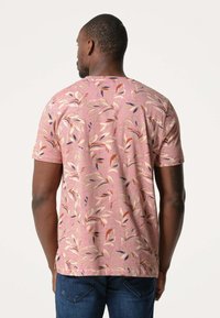 Korte mouw shirt in roze met witte en multikleurige bladerenpatronen. Gemaakt van een zachte stof met een relaxed fit en een ronde hals.